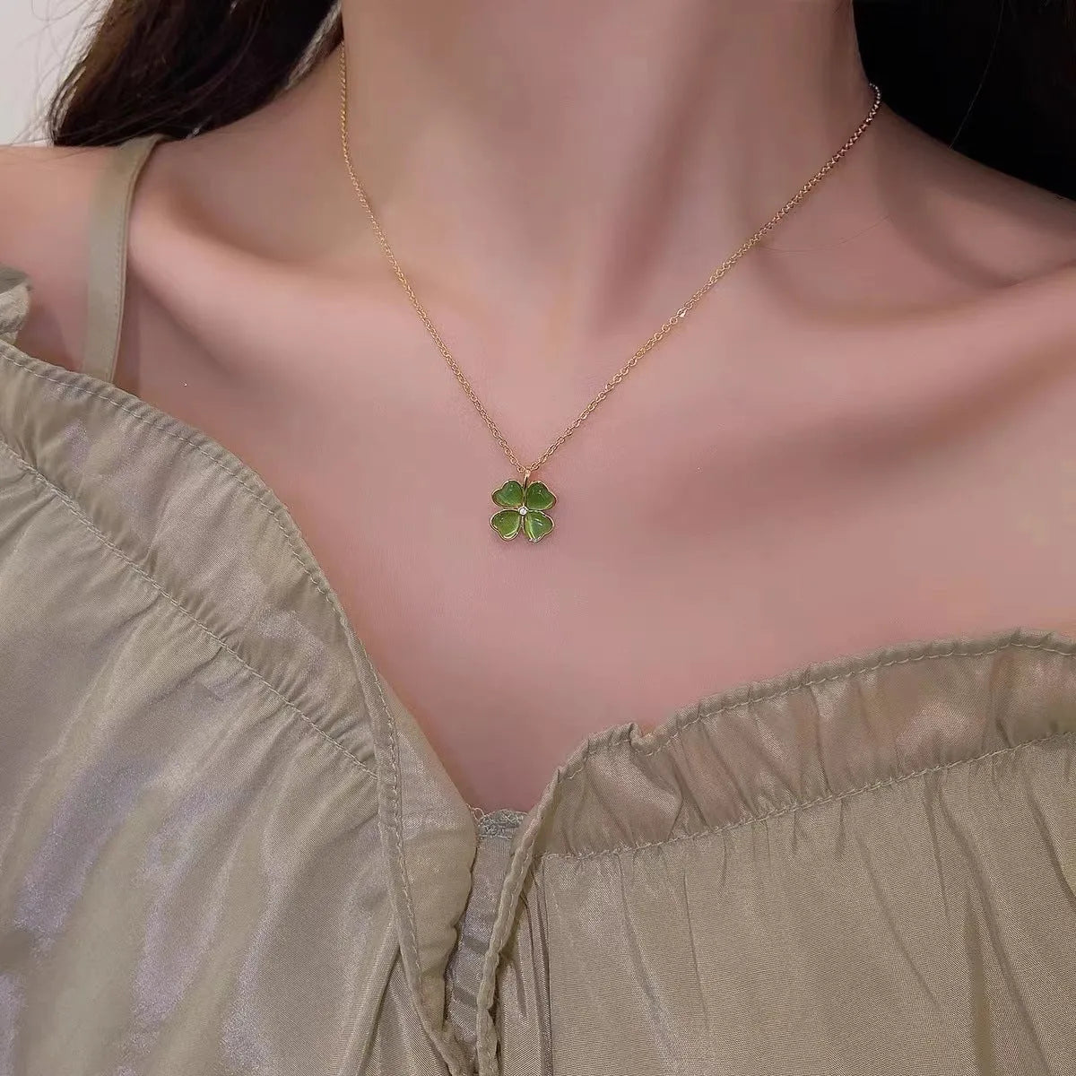 Titanium steel golden clavicle chain with geometric four-leaf flower design on unisex display