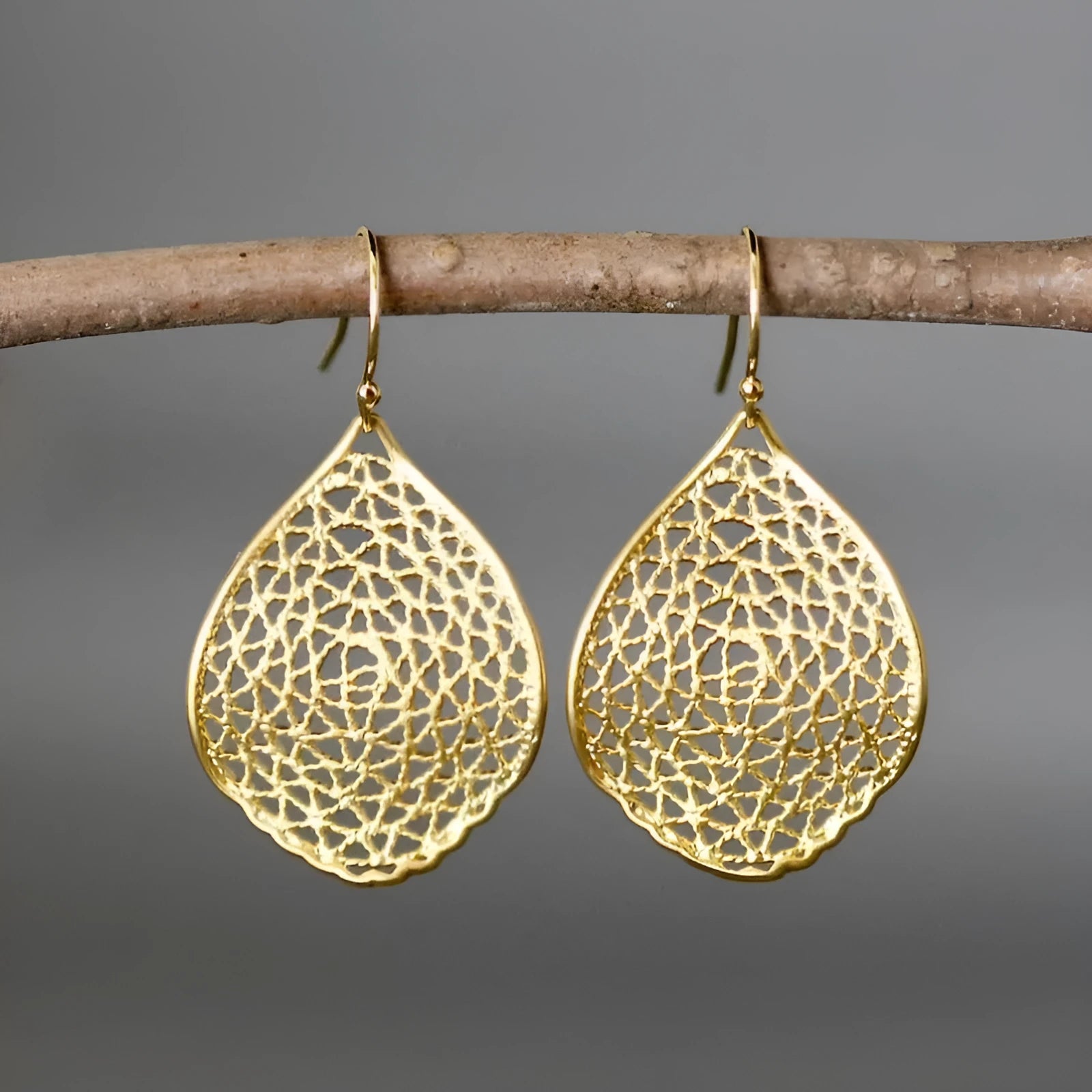 Gold-coloured alloy retro earrings with hollow leaf pendant in drop shape