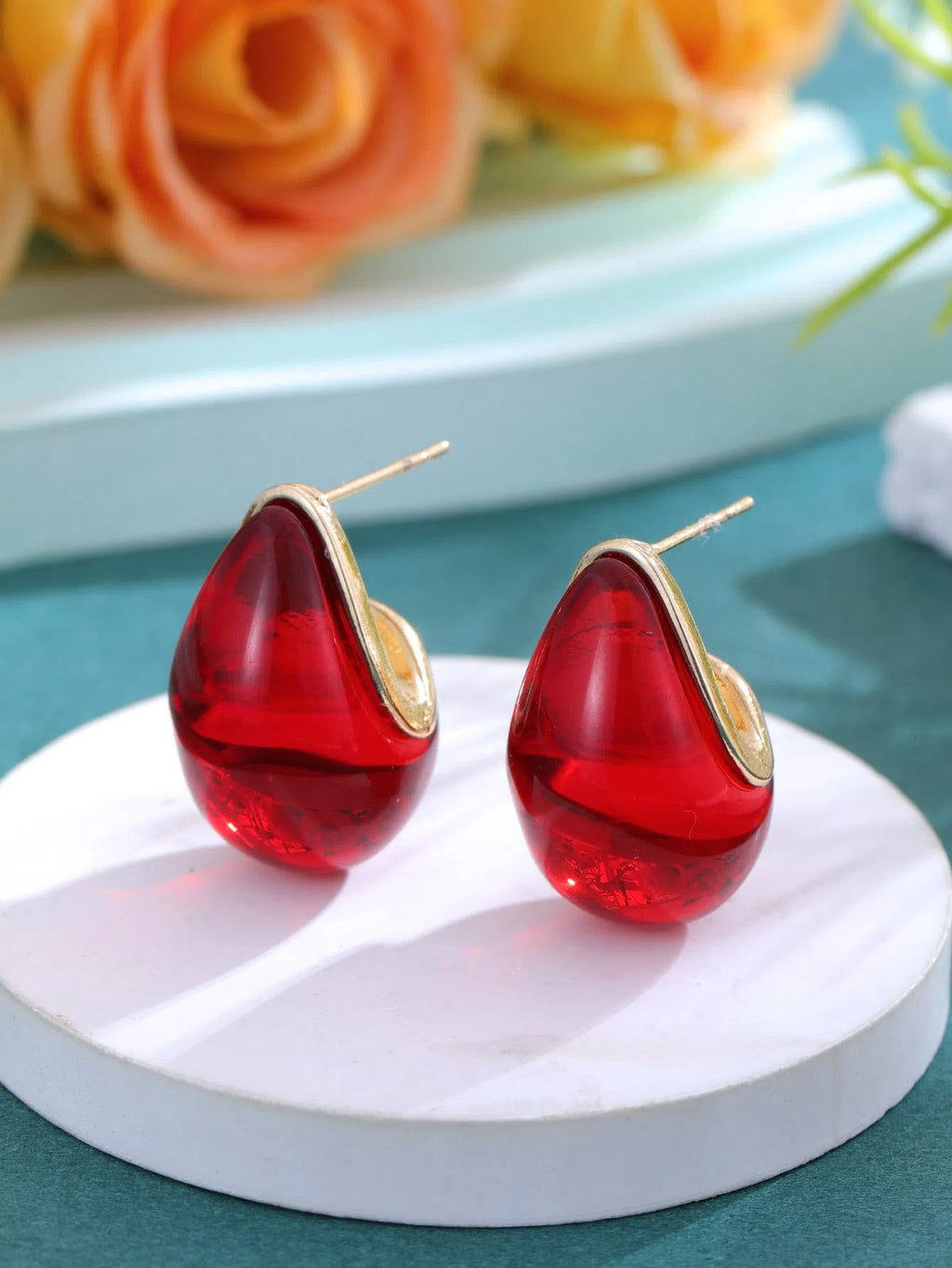 Water droplet retro earrings in brown colour with shiny pendant on white background