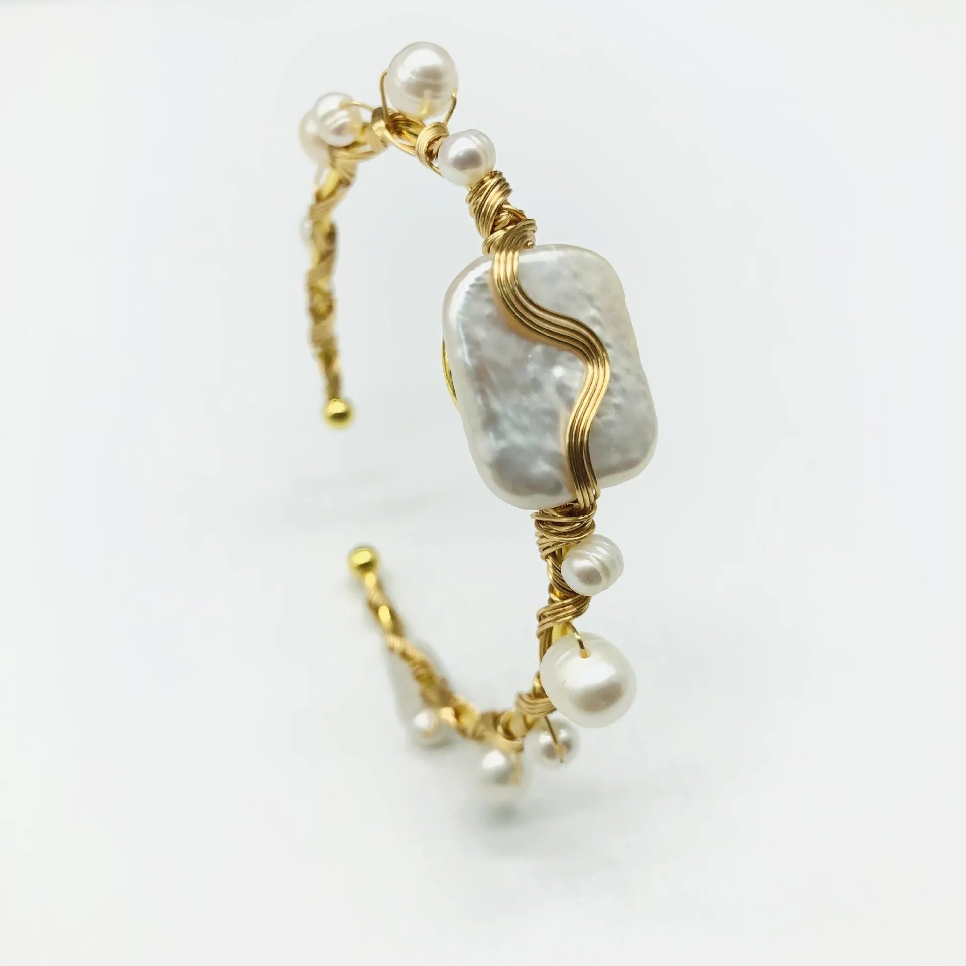 Natural freshwater pearl bracelet with gold titanium steel wire-wrap on hand model