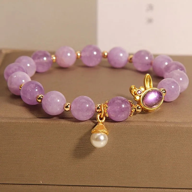 Natural mauve jade rabbit bracelet with crystal band and purplish red hare head charm.