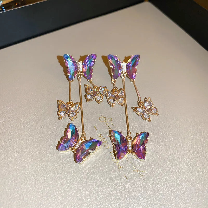A pair of women's silver-plated alloy tassel drop earrings with crystal flowers in a blue purple butterfly colour.