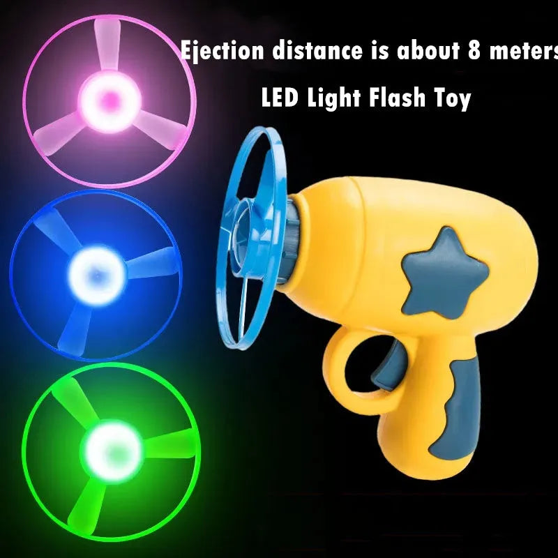 Plastic flying saucer launcher toy set with LED lights and coloured discs on outdoor grass.