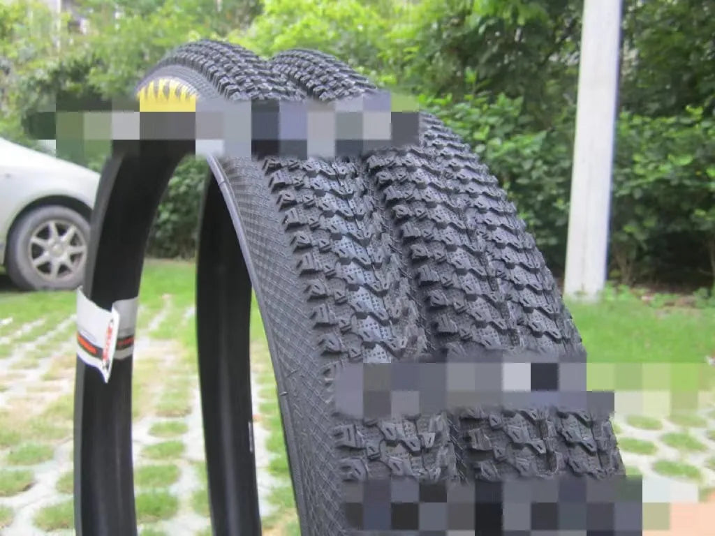 Ultralight puncture-proof mountain bike tyre in multiple sizes on a grey background.