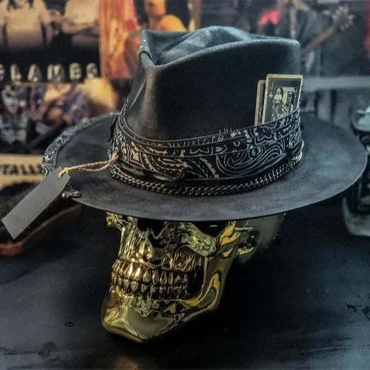 Handmade wool felt hat with conical crown and skull embroidery on a denim base.