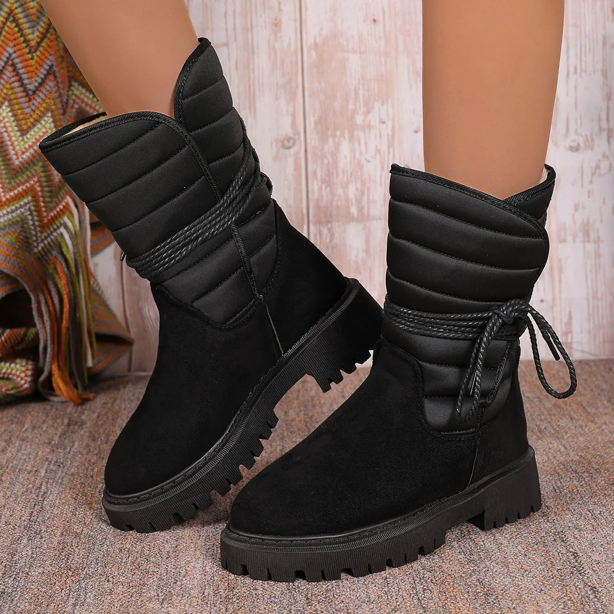 Black women's chunky heel snow boots with lace-up design and suede upper on a rubber sole