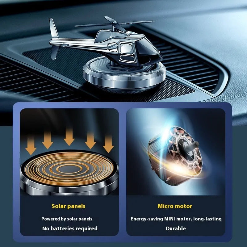 Silver metal solar helicopter car perfume ornament rotating on a car dashboard.