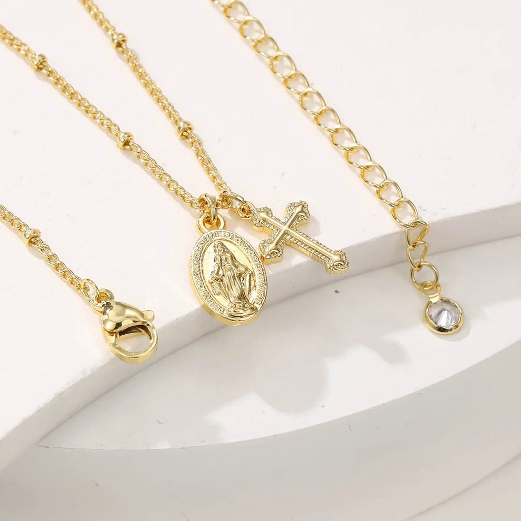 Gold geometric pendant necklace featuring the Virgin Mary on a chain.