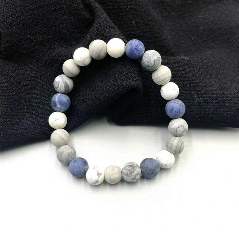Handmade natural planet stone bracelet with starry design on a wrist, showing U-shaped profile.