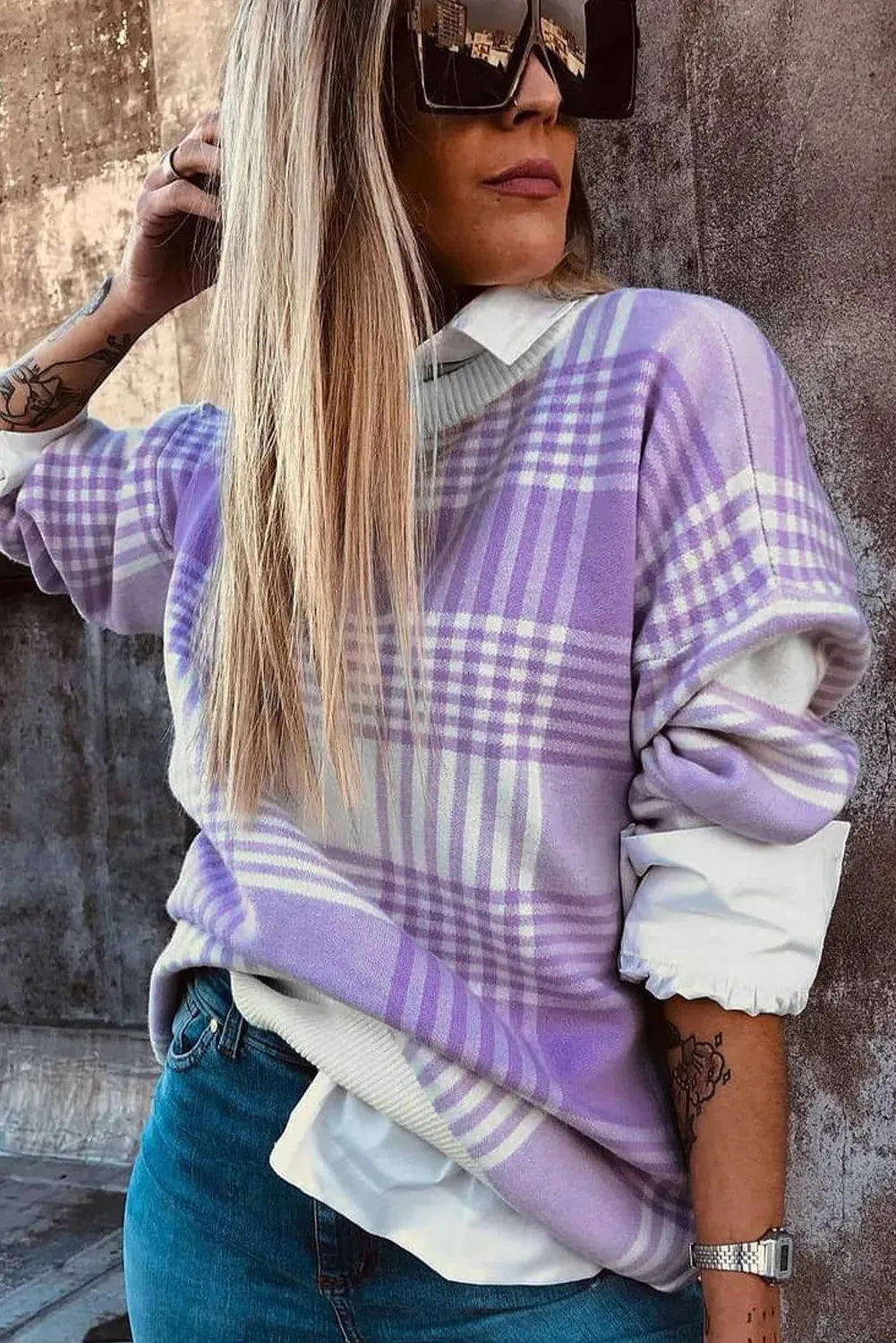Loose lilac plaid print sweater with ribbed trim and long sleeves on a hanger.