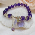 Purple amethyst bracelet with ethnic money bag pendant and peace buckle closure on wrist