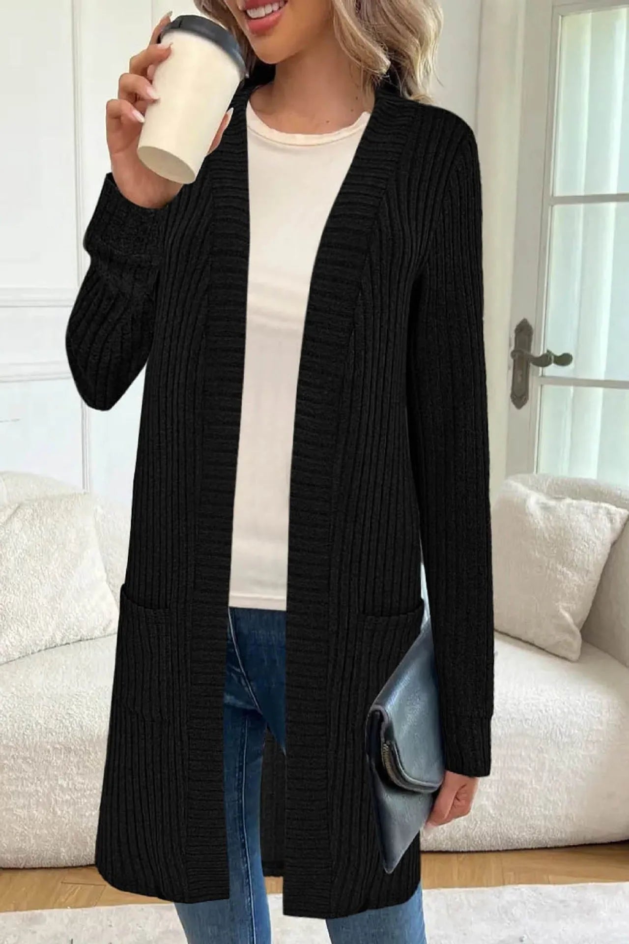 Black loose fit knitted cardigan jacket with long sleeves and side pockets on a mannequin.