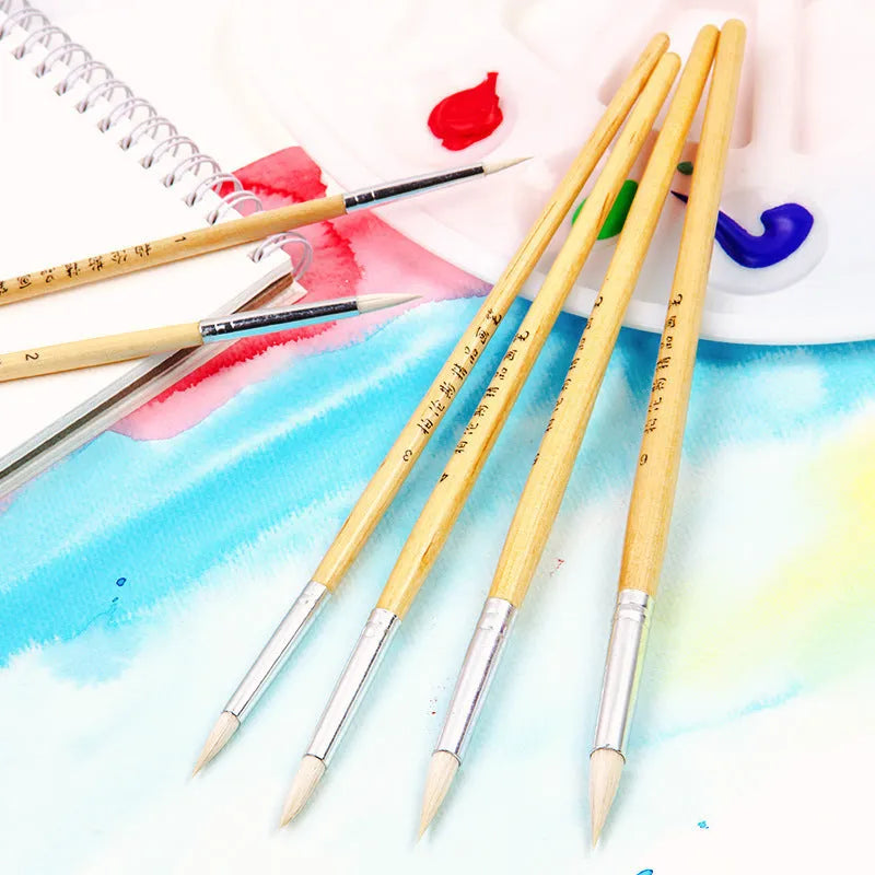 6 wooden artist paintbrushes with pointed handles and wool brush heads arranged together