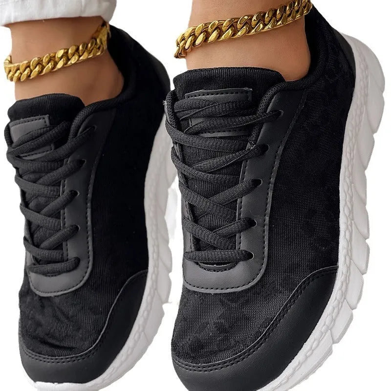 Women's white canvas casual running shoes with soft flat soles on a light background.