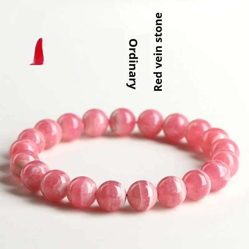 Women's red rhodochrosite crystal bracelet with geometric beads and longevity lock charm on wrist