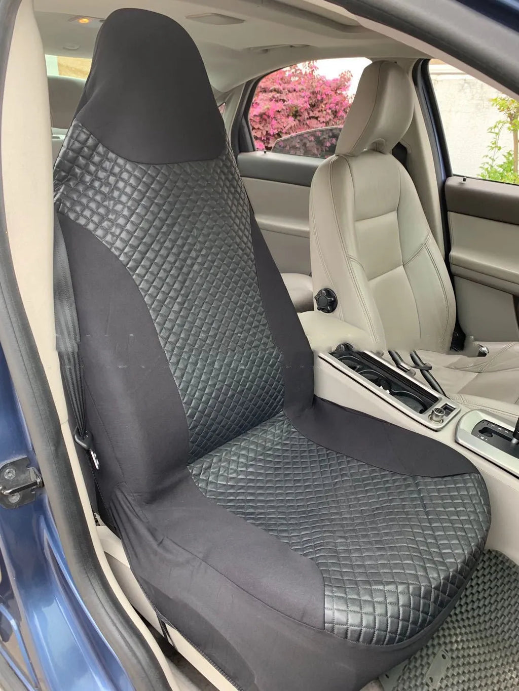 Black quilted car seat cover made of PU and polyester fabric with sponge padding.