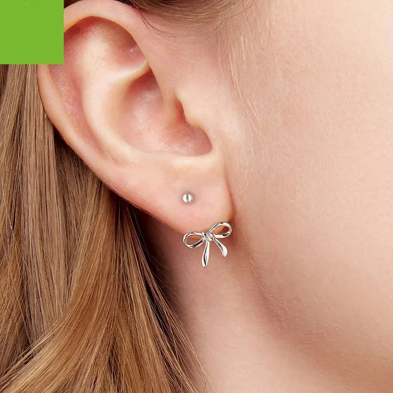Women's S925 sterling silver bow stud earrings, polished silver finish, 1.2 cm bow shape on white background