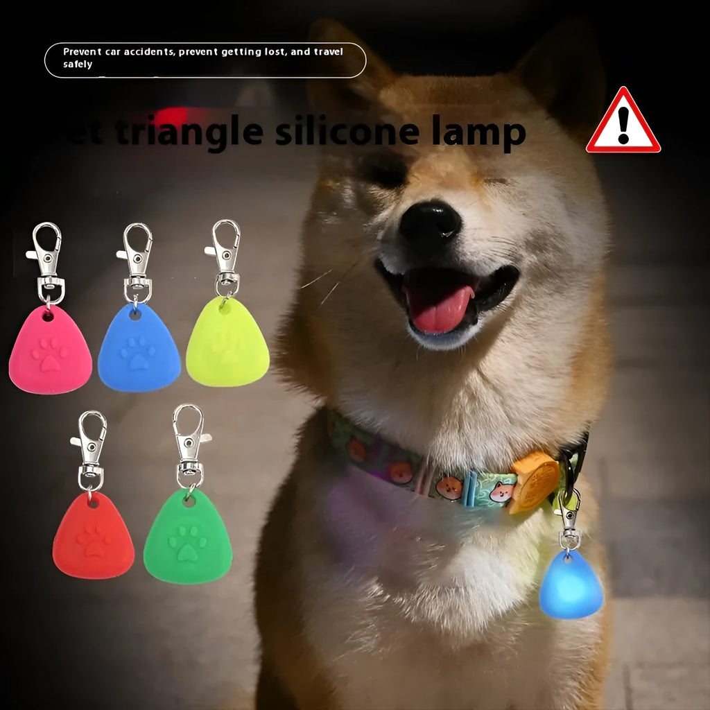 A glowing triangular silicone pendant ornament for pets, shown in various colours on card packaging.
