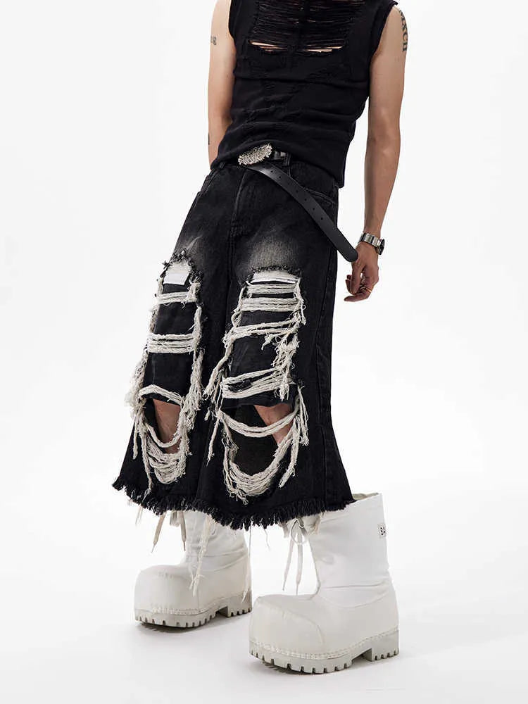 Black wide-leg cropped jeans with a ripped patch detail on the leg, showing a mid-high waist and loose fit.
