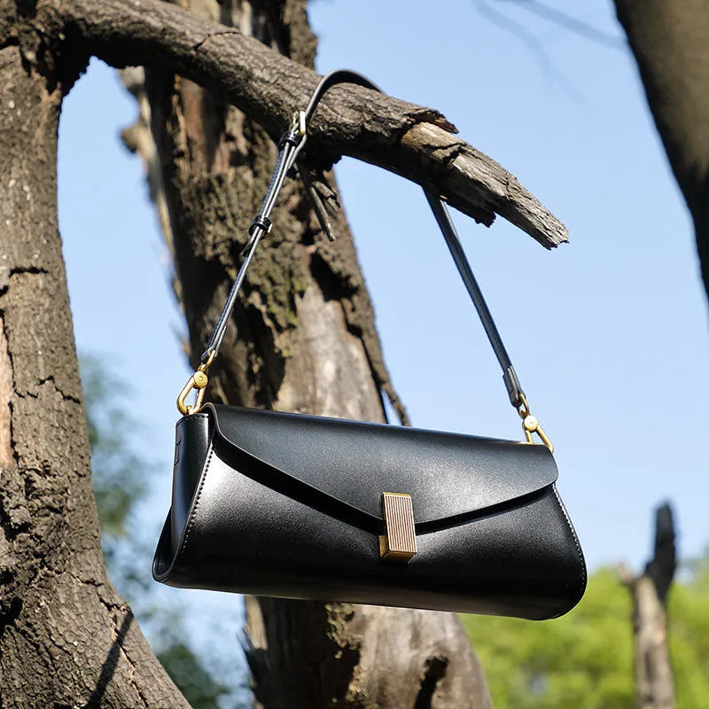 Women's cowhide leather cross-body bag in pillow shape with clamshell opening, shown in milky white colour