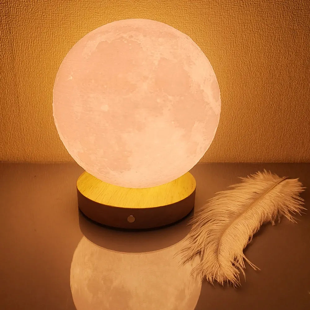 Rotating sleeping moon night lamp on a wooden base with a wire control, showing three colour options.