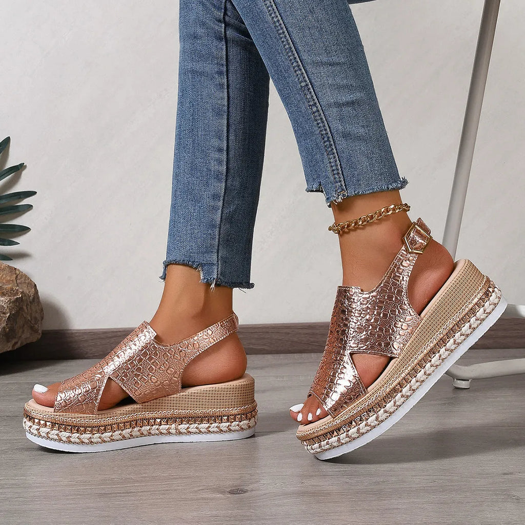 Gold Roman sandals with hollow-out pattern and ankle buckle on model foot