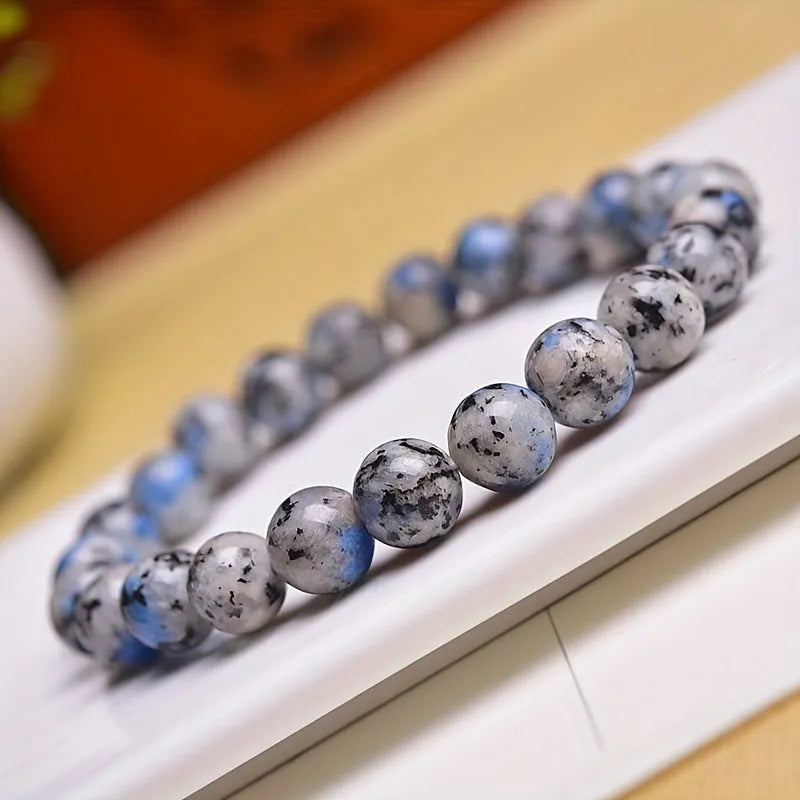 Handmade blue-green K2 Azurite stone bracelet with geometric beads on a wrist.