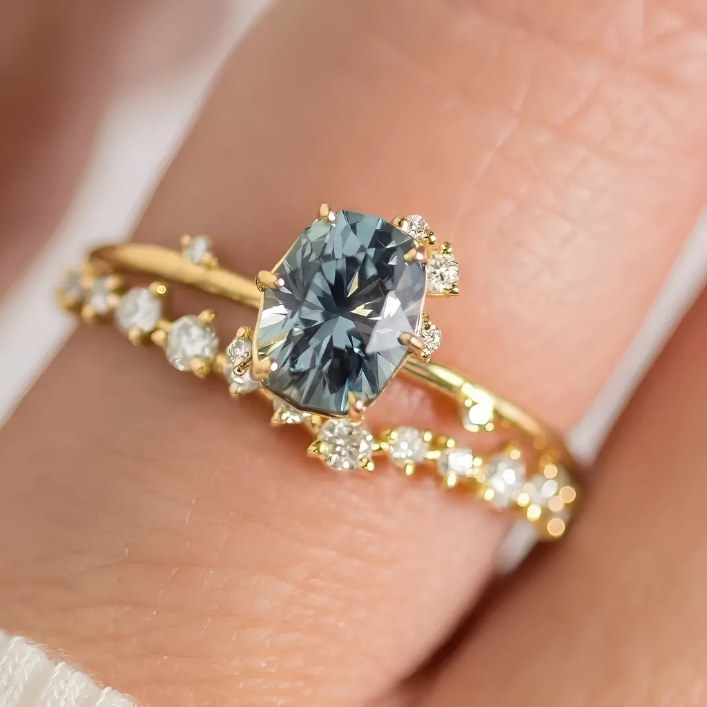 A pair of gold-plated floral rings with a central green zircon stone on a white background.