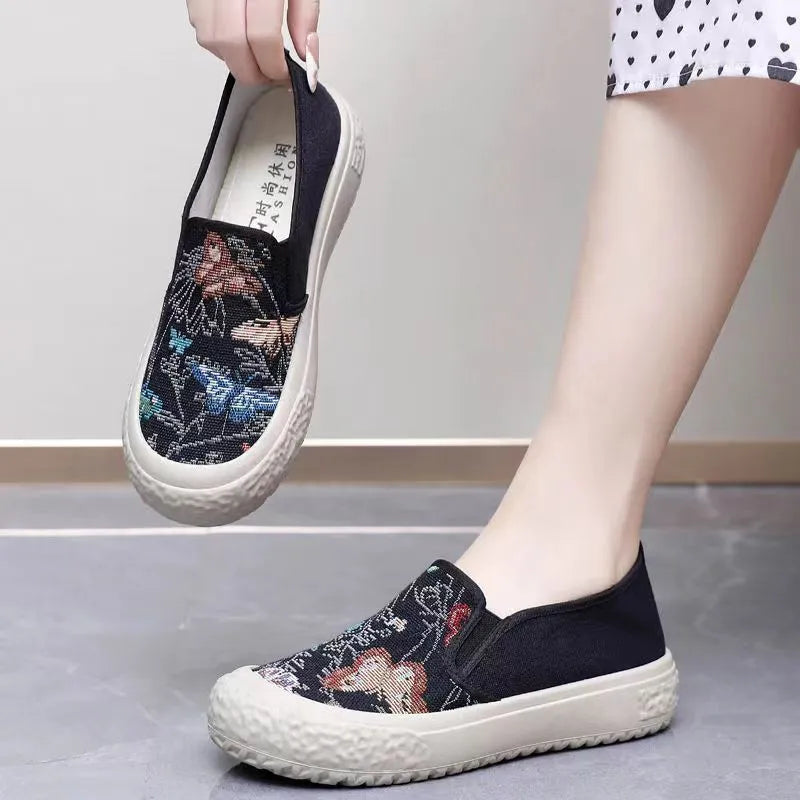 Women's canvas slip-on shoes with plastic soles in black and white colours showing sewing thread decoration
