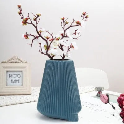 Colourful melamine plastic decorative flower vase on a desk, showing white, pink, green, and blue colour options.