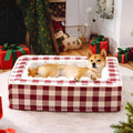 Classic plaid pattern dog cushion with removable cover in red, shown next to a black crate.