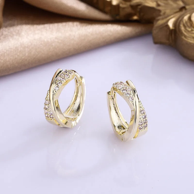 A pair of geometric earrings in 14K yellow colour, made from copper with a zircon treatment.