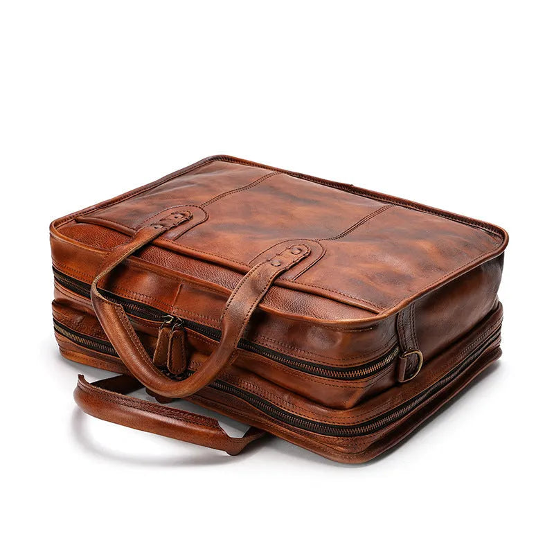 Vintage brown leather men's briefcase showing internal laptop and camera compartments.