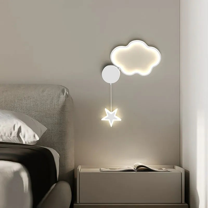 White cloud-shaped children's wall lamp with LED light mounted beside a bed.