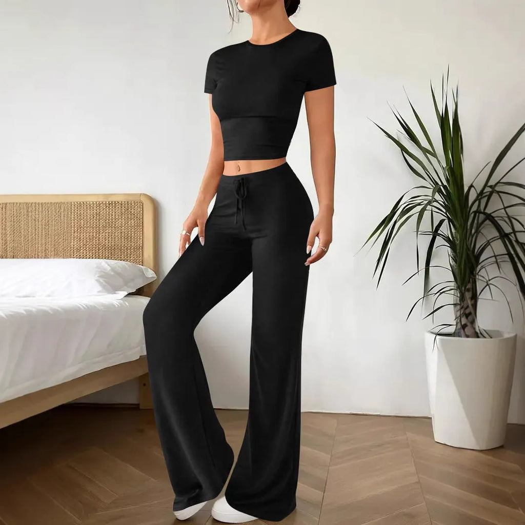 Black high-waist trousers and matching short-sleeve T-shirt co-ord set laid flat.