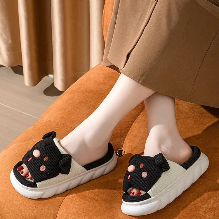 A pair of open toe linen slippers for couples on a light background, showing the flip-flop style and linen upper texture.