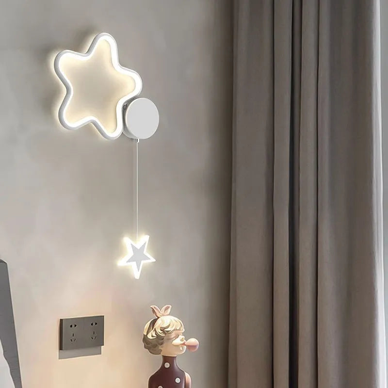 White cloud-shaped children's wall lamp with LED light mounted beside a bed.