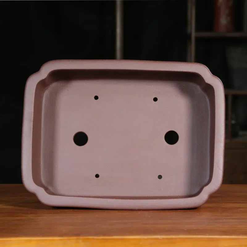 Antique-style rectangular purple sand bonsai pot on a floor.