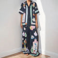 Black women's casual set with cartoon print, featuring a top with regular sleeves and matching trousers.
