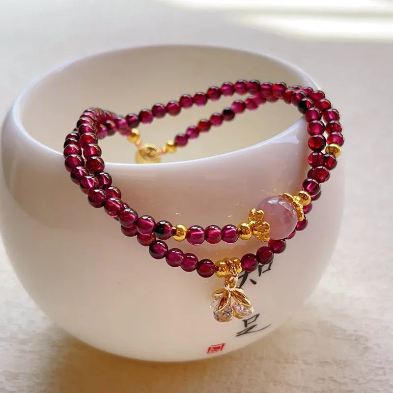 Women's double ring bracelet with natural red garnet beads and adjustable clasp.