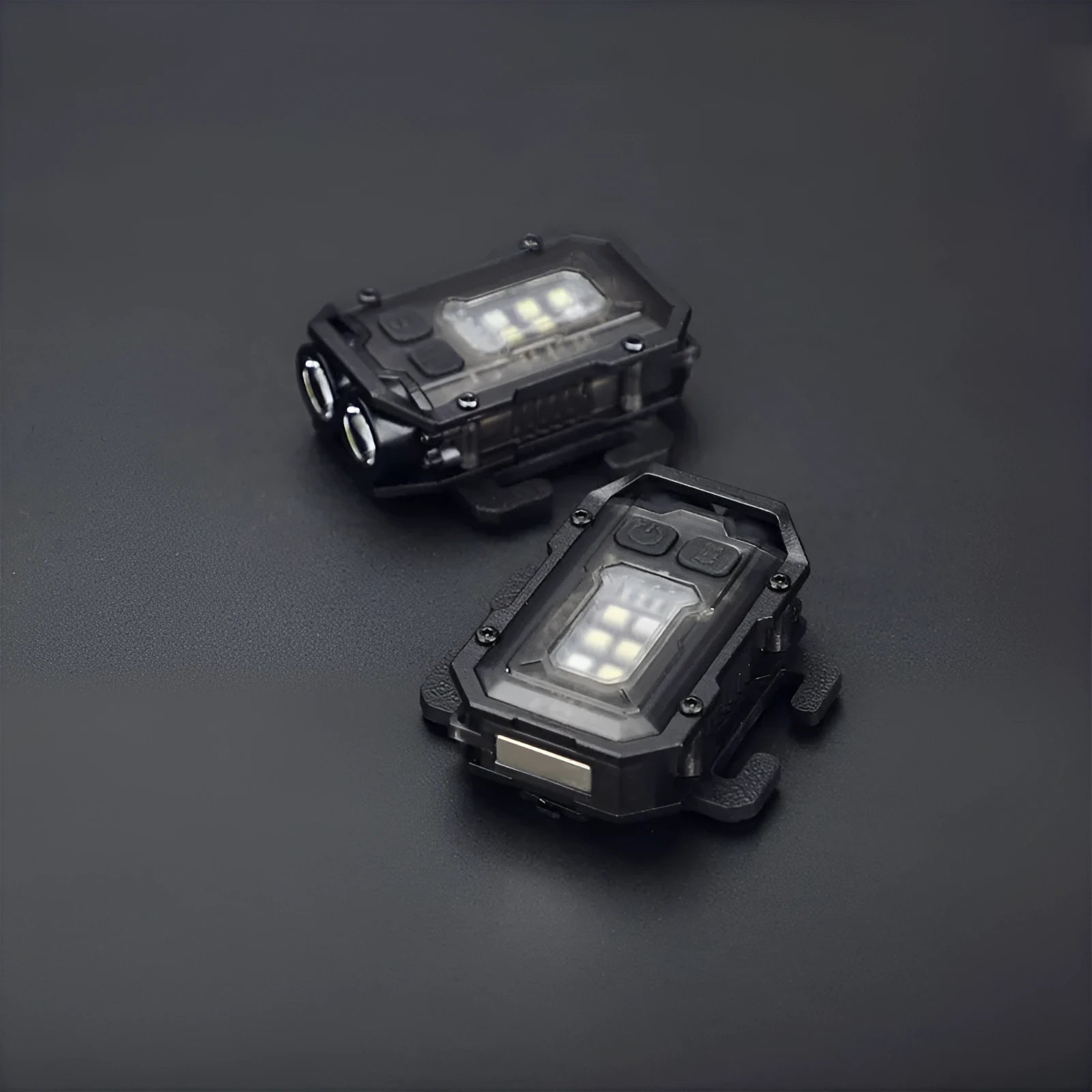 Black portable tactical mini warning flashlight with USB charging cable on a backpack strap.