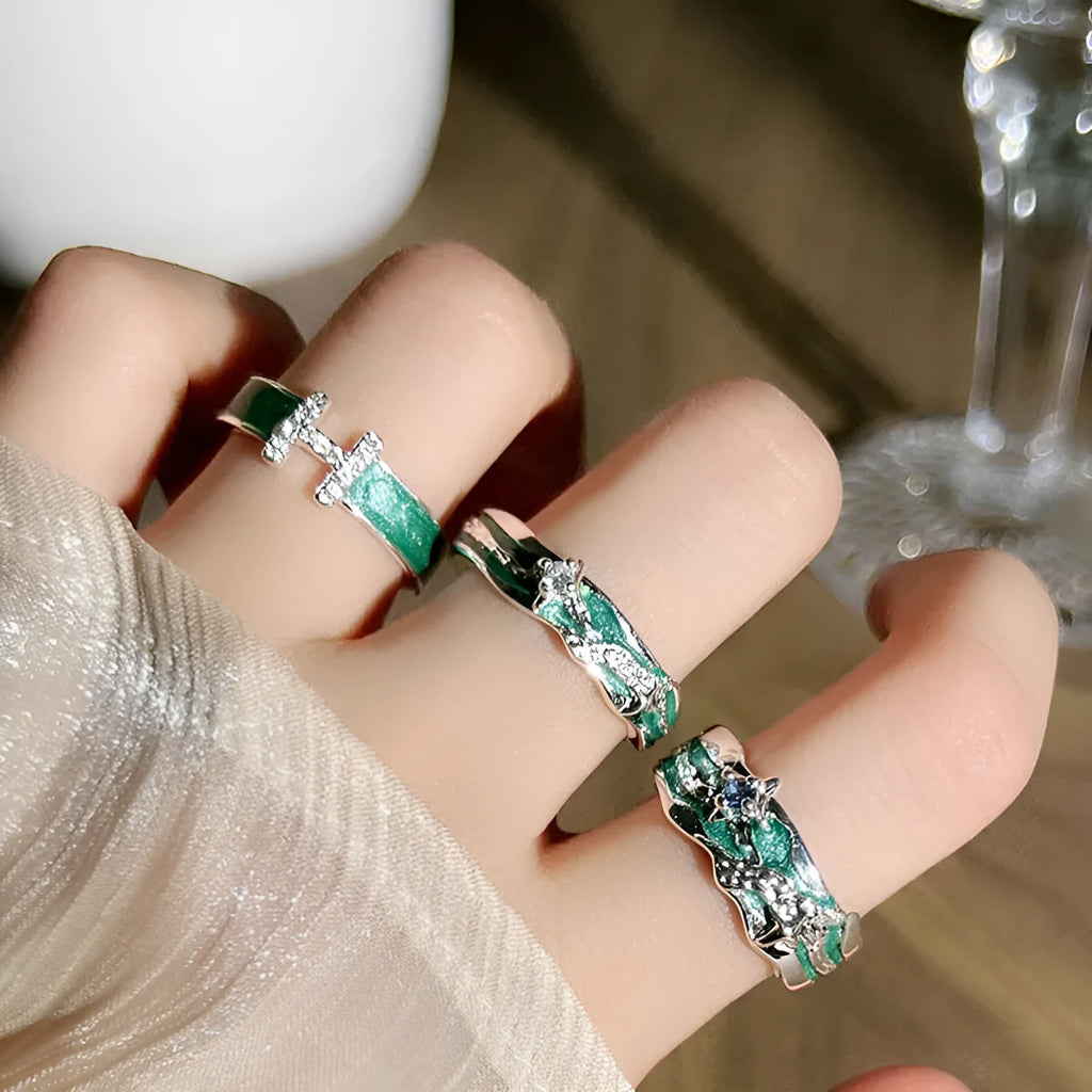 Mint green enamel eight-point asterism ring on a copper base, showing asymmetric and folded design details.