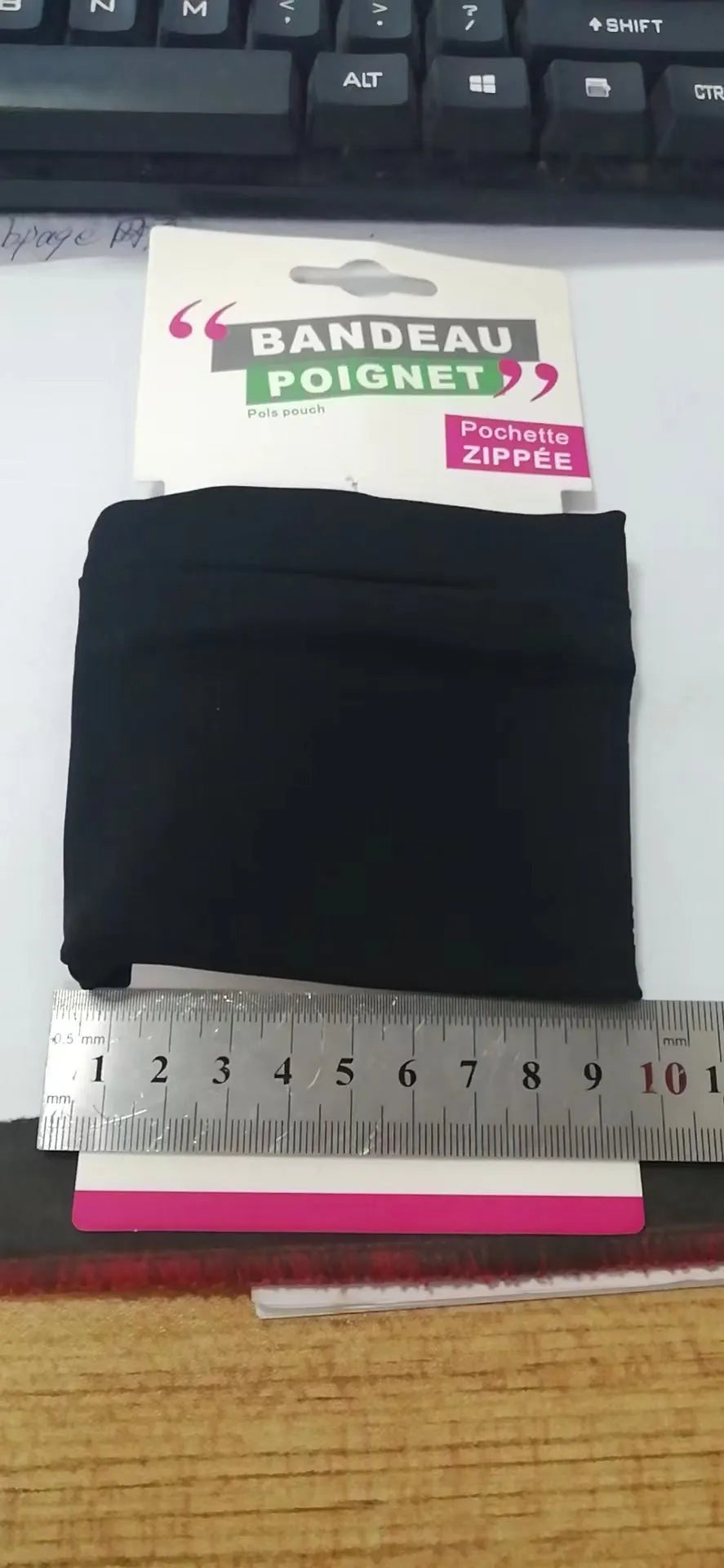 Compact 10 by 10.5 cm black armband sleeve for mobile phone, shown with packaging.
