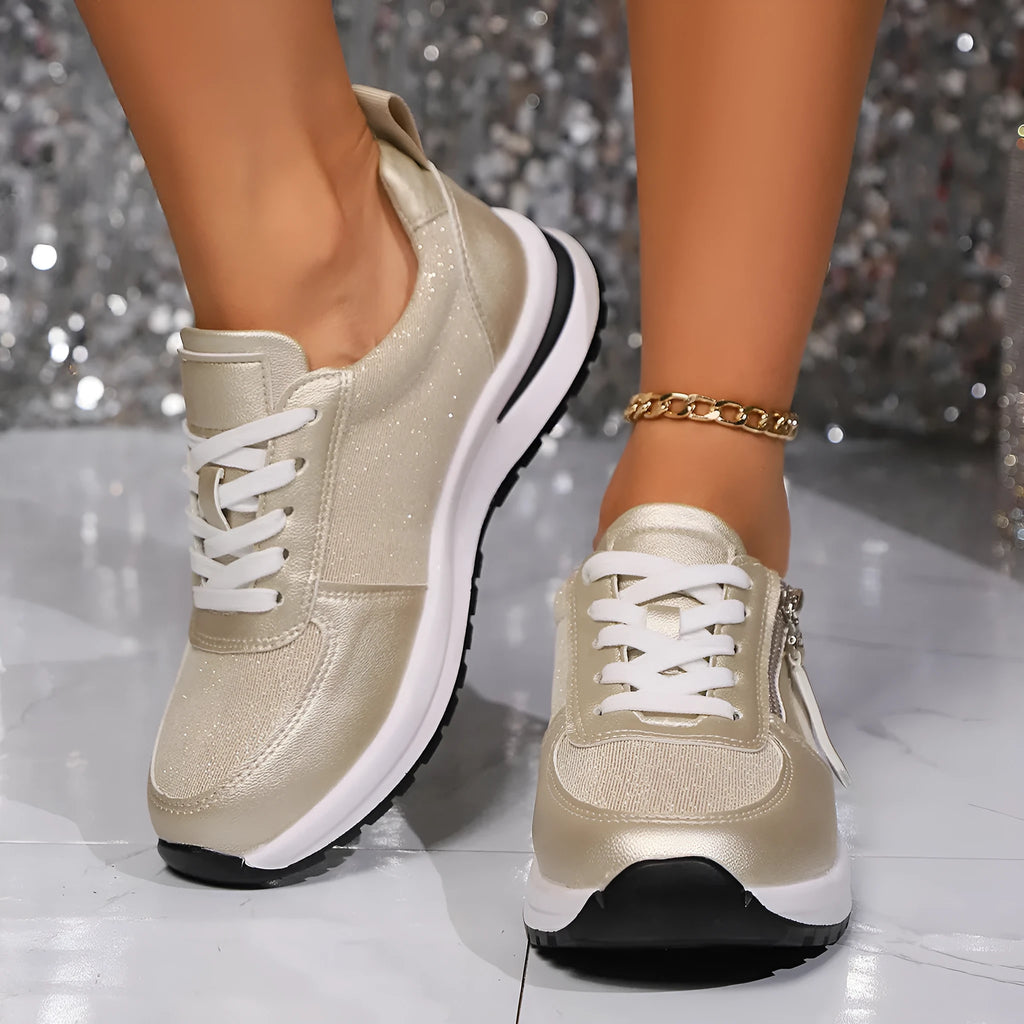Gold women's flat lace-up pumps with round toe and shallow cut on a white background.