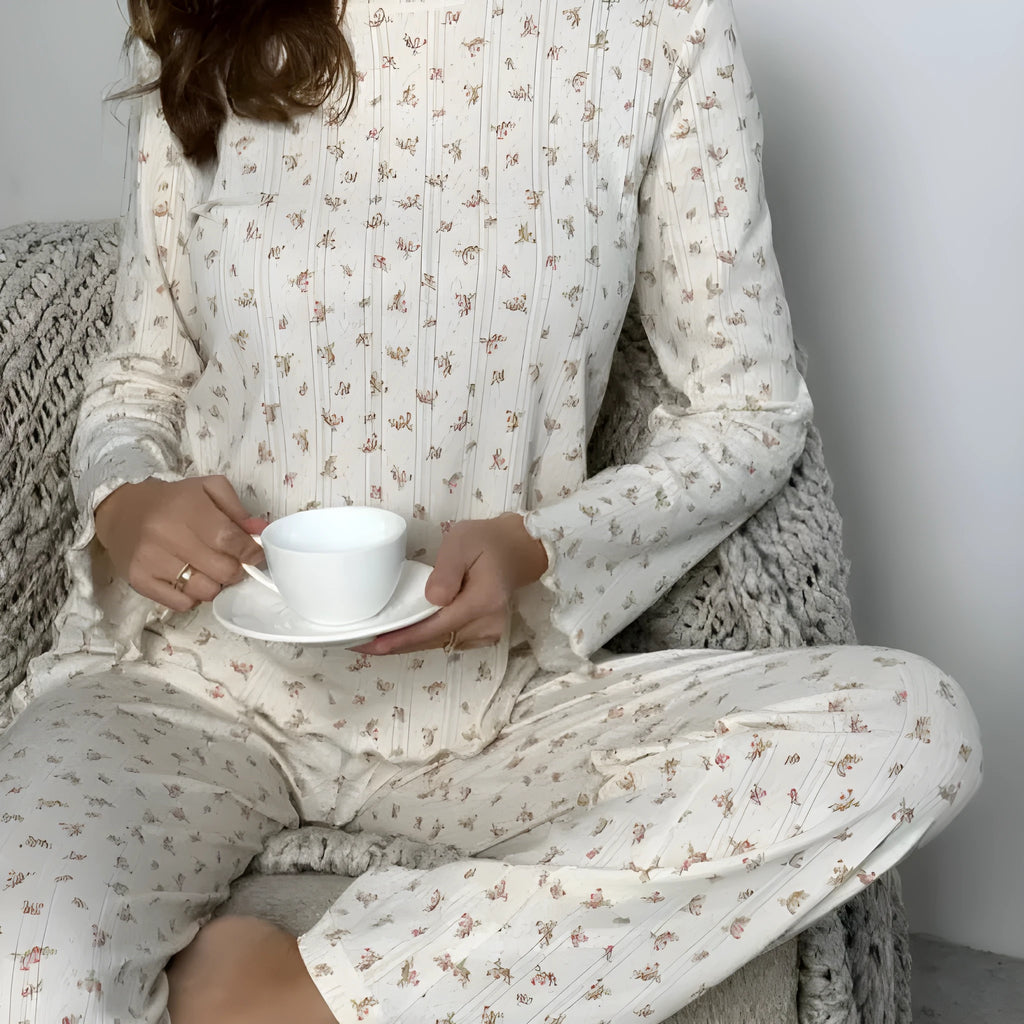 White women's floral print lounge suit with long bell sleeve top and wide leg trousers.