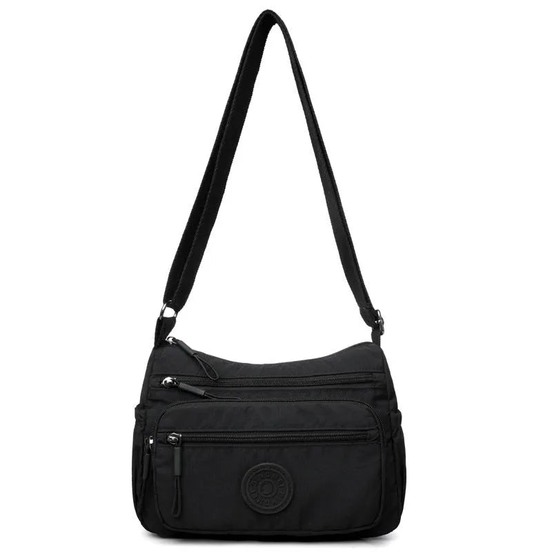 Grey water-repellent nylon crossbody bag showing three-dimensional pockets and a single shoulder strap.