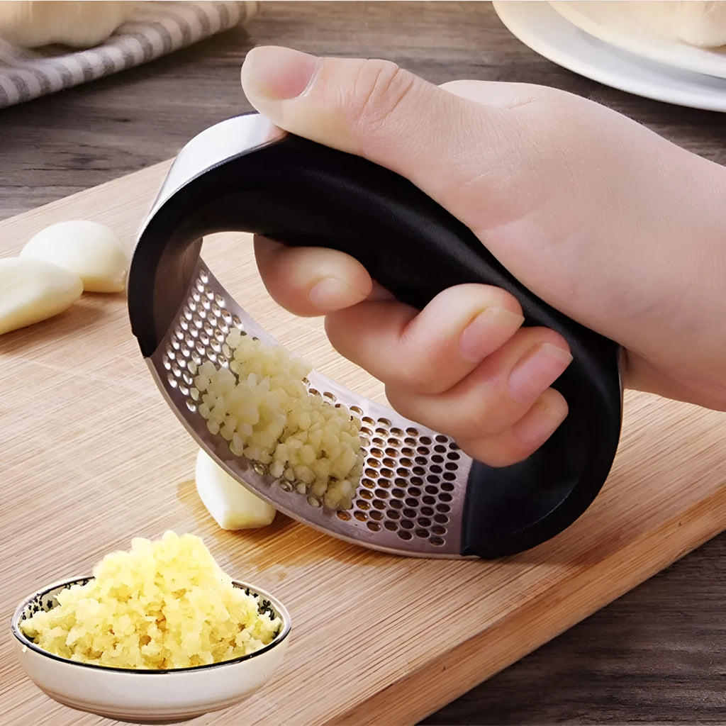 Stainless steel garlic press with curved ergonomic design and non-slip handle in assorted colours.