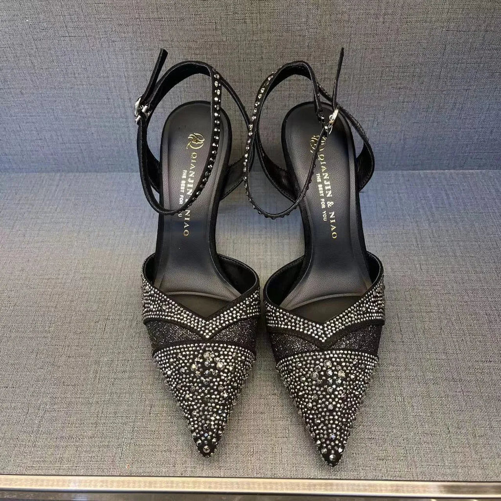 Women's black hollow stiletto heel pump shoe with pointed toe and red sole on a white background.
