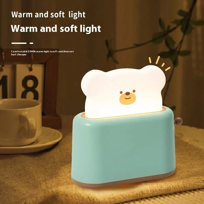 Bread bear shaped silicone night light with warm yellow glow on a desk