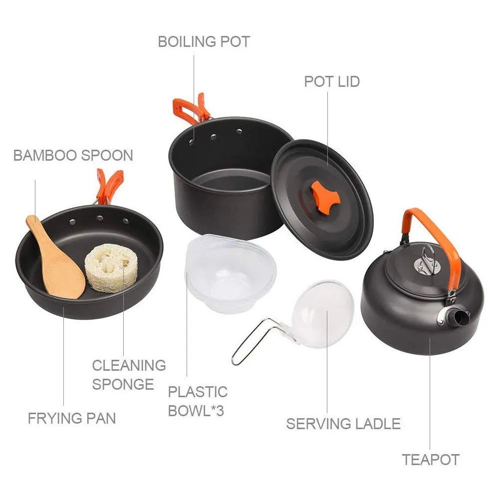 Orange folding camping cookware set with pots, pan, spoons, bowls in mesh bag on outdoor table